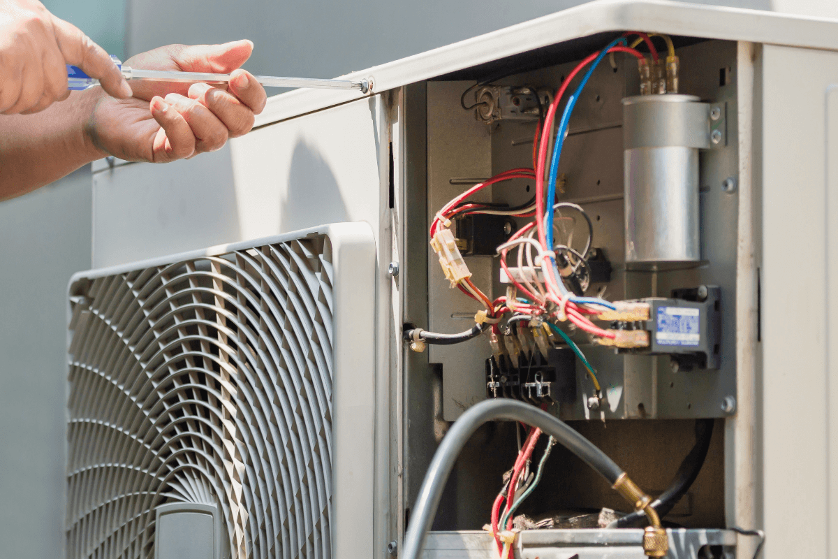 Technician diagnosing failed air conditioner at Tampa home during afternoon heat