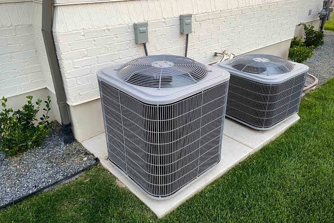 HVAC installer measuring airflow and checking system connections during equipment setup
