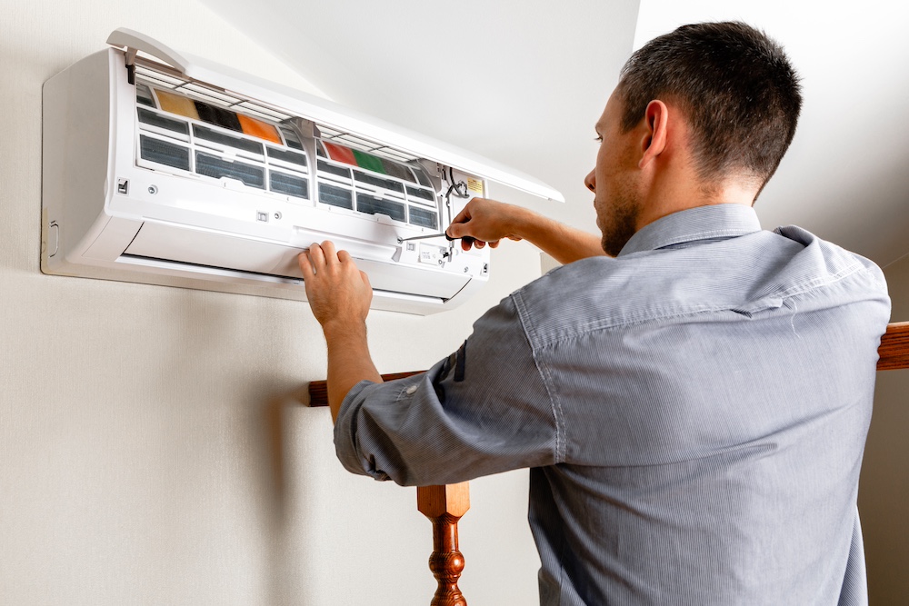 New central air conditioning unit being installed beside North Las Vegas home